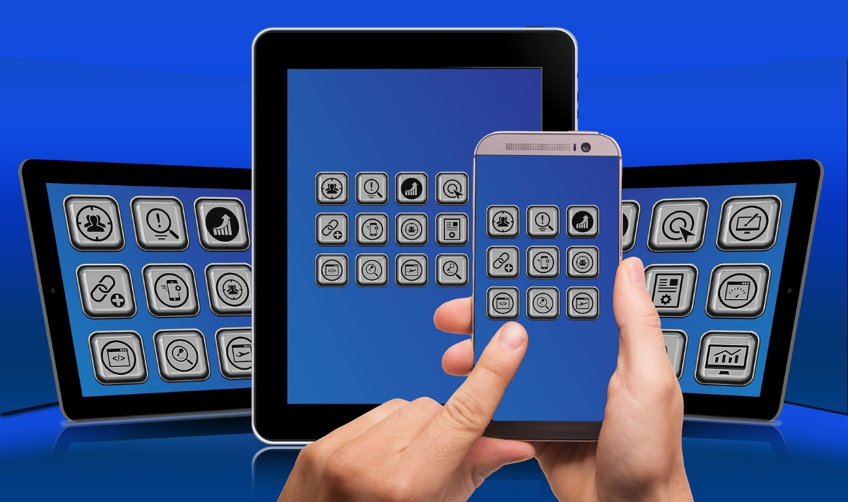 (Image) A hand hovers over an array of screens, each showing many app icons.