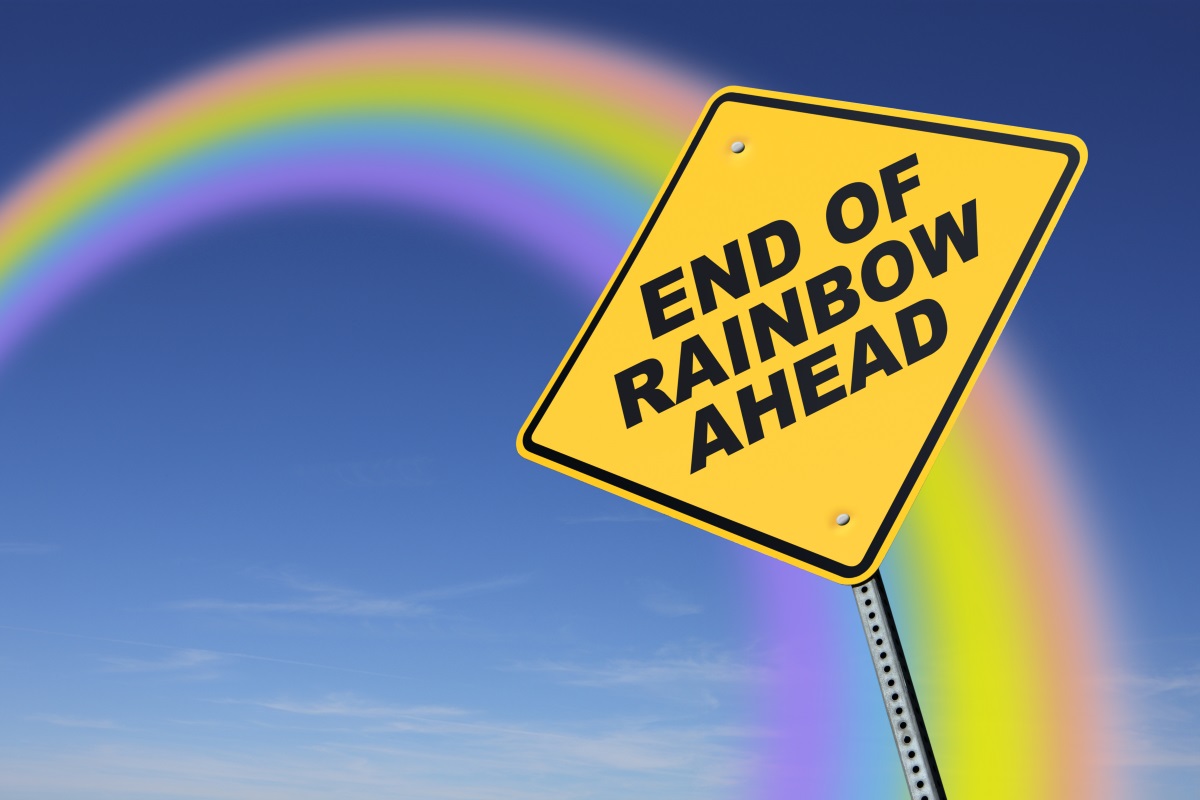 A road sign reads “End Of Rainbow Ahead”, while a rainbow arches in the background.