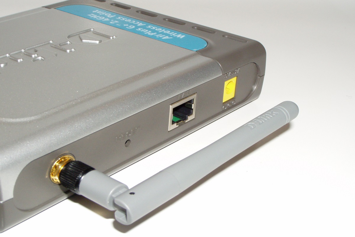 Image: A close-up of a wireless router, showing the antenna laying across the table.