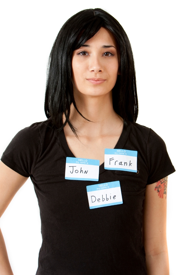 a tough-looking young woman wears three different nametags: John, Frank, and Debbie