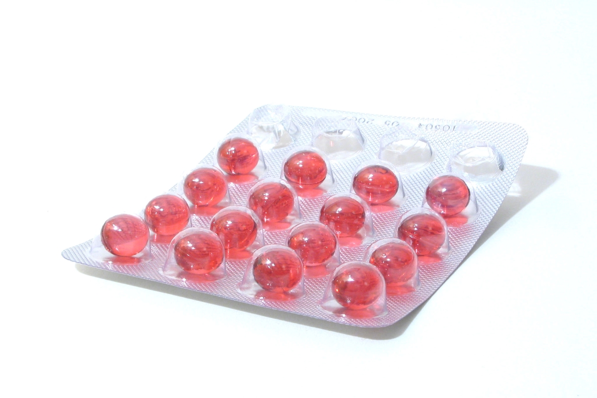 A blister pack of red pills on a white background.