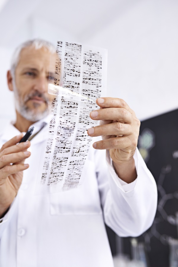 a researcher reviews a sheet of DNA testing results.